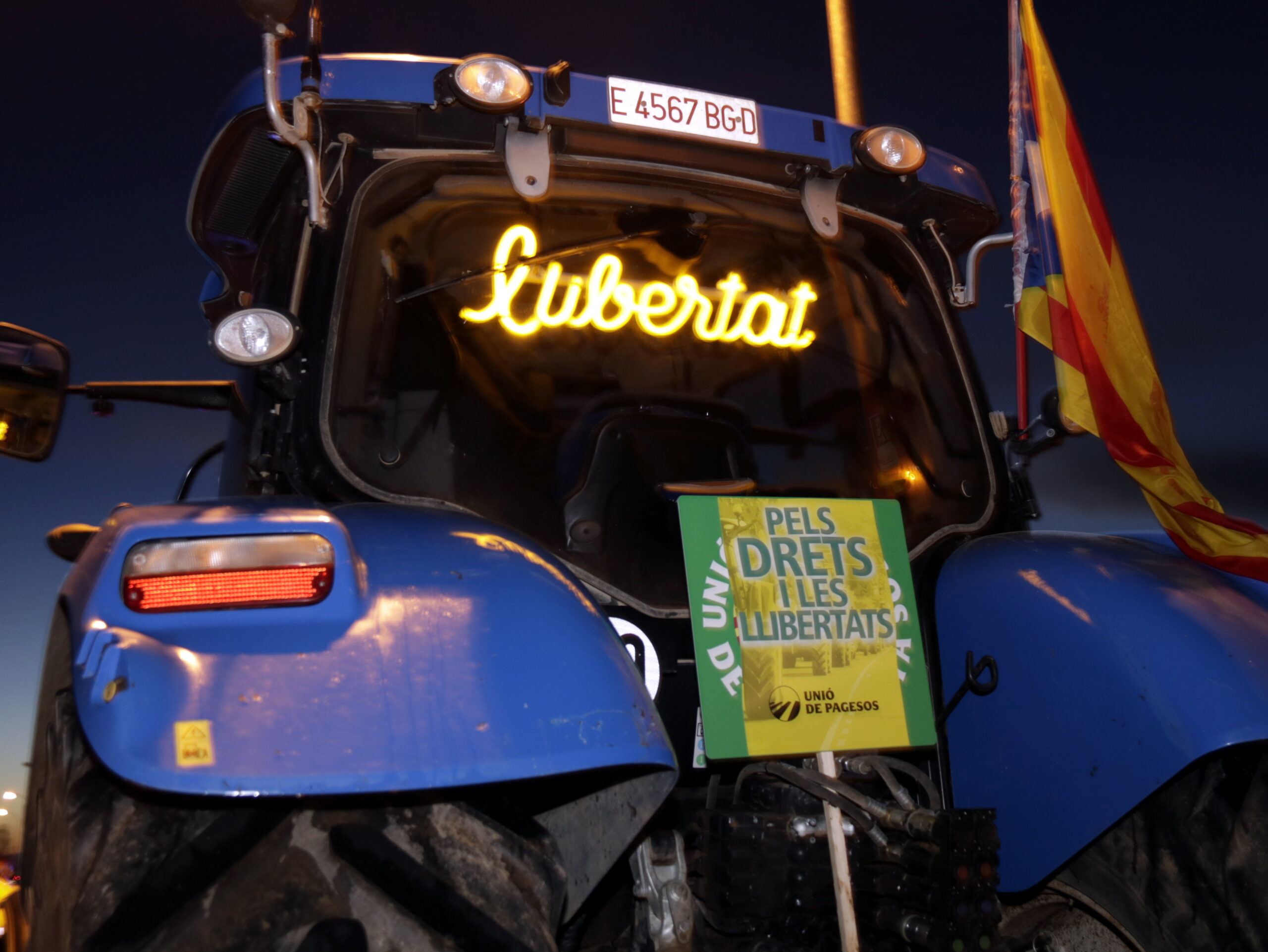 Pla curt d'un tractor que porta un panell lluminós amb la paraula 'llibertat' i un cartell de la tractorada a Mollerussa, el 21 de desembre de 2019. (Horitzontal)